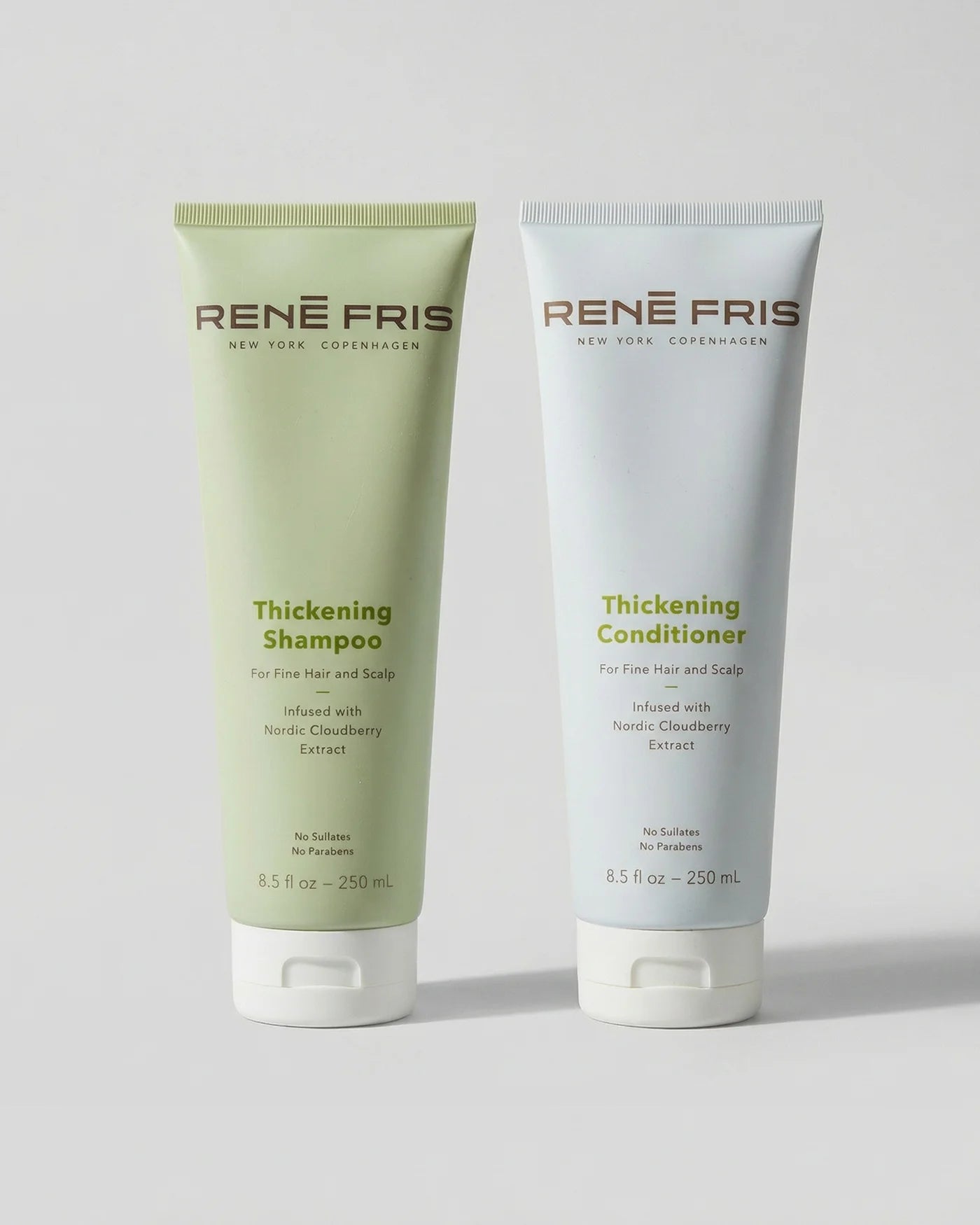 Two tubes of Rene Fris Thickening Shampoo and Conditioner on a light gray background
