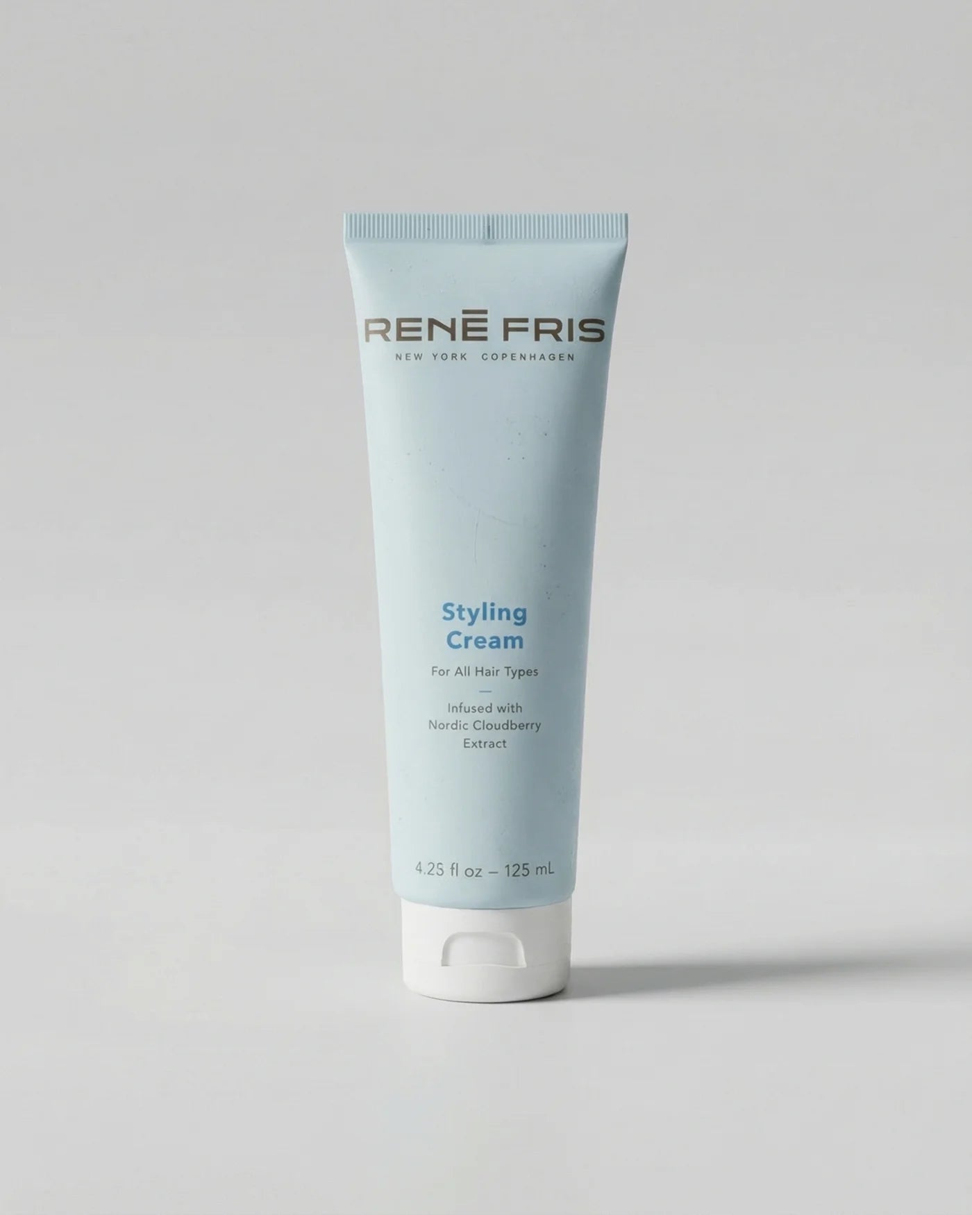 Tube of Rene Fris Styling Cream on a gray background